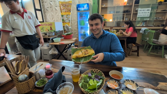 Liam d&ugrave;ng bữa tại một qu&aacute;n b&aacute;nh x&egrave;o địa phương. Ảnh: NVCC