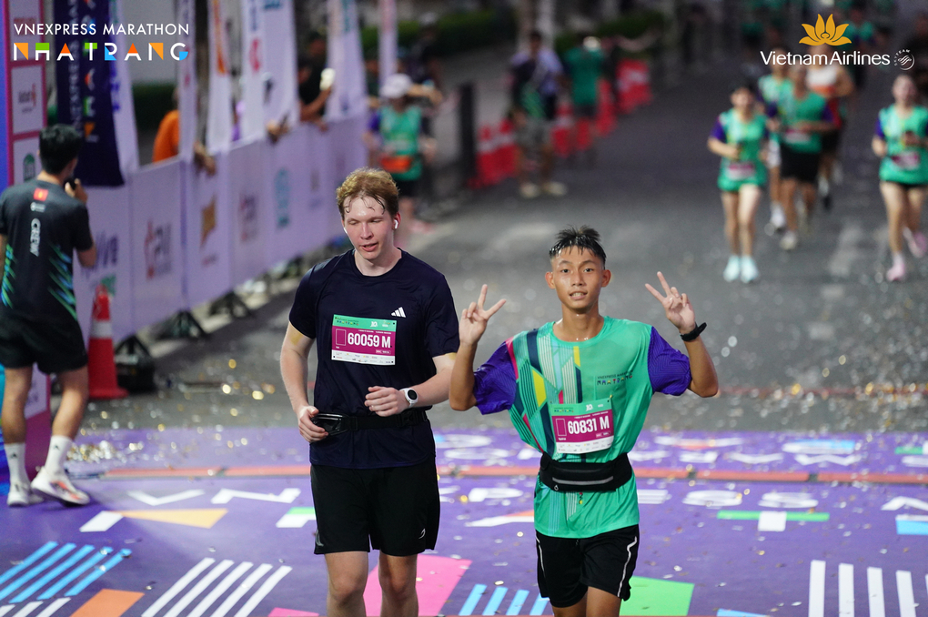 Ivan (tr&aacute;i) trong khoảnh khắc về đ&iacute;ch c&ugrave;ng một VĐV người Việt. Ảnh: VnExpress Marathon