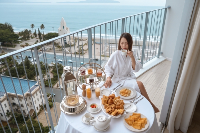 Kh&aacute;ch lưu tr&uacute; thưởng thức tr&agrave; chiều tr&ecirc;n ban c&ocirc;ng kh&aacute;ch sạn với tầm nh&igrave;n hướng ra Quảng trường 2/4, th&aacute;p trầm hương v&agrave; biển. Ảnh: The Empyrean Nha Trang